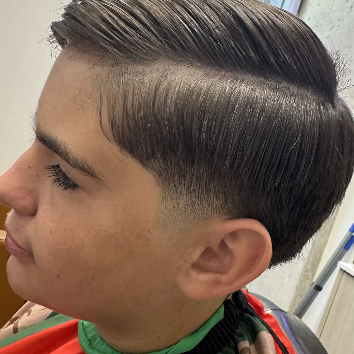 A finished cut by Aldo seen in profile, blended tight around the ear
