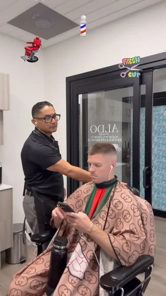 Aldo lining up a client's cut with clippers