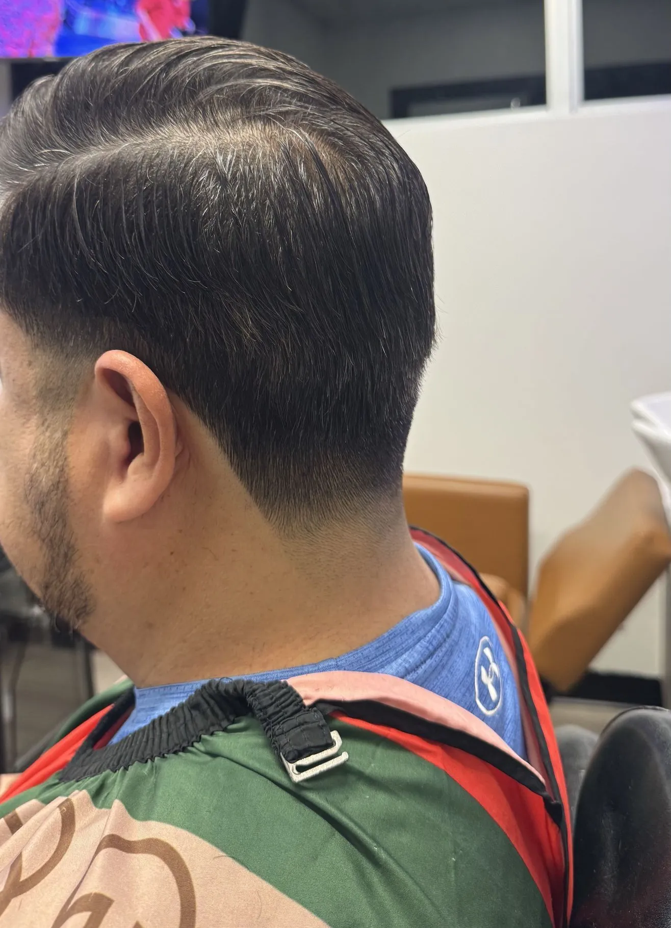 Tapered haircut by Aldo, shown from behind, weight kept on top and cleaned at the neck