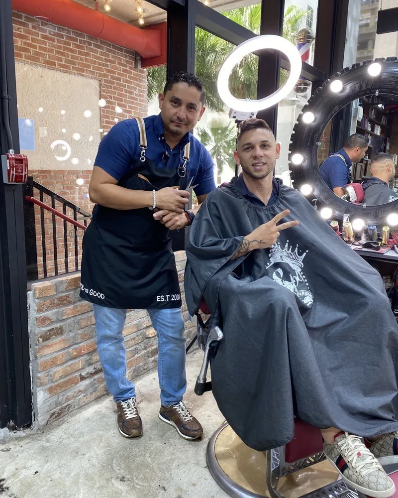Aldo and a client at the chair by the shop's front entrance